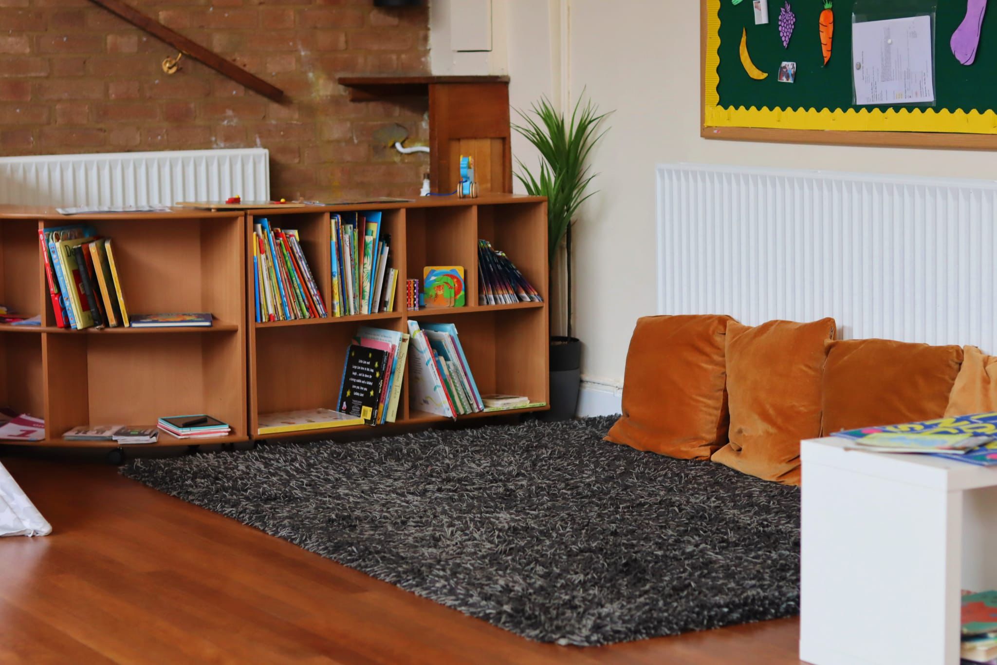 Calm and organised nursery reading area with books and learning displays at Maygardens Little Learners